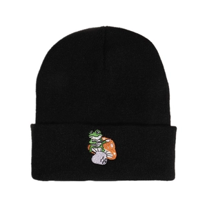 Black knit beanie with green frog embroidery playing an instrument for winter