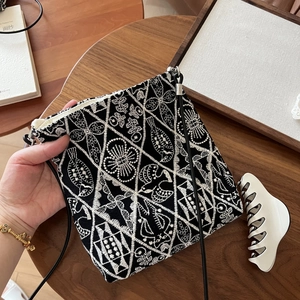 Detailed close-up of tribal embroidery and geometric patterns on a canvas crossbody bag