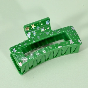 Detail showing green Christmas hair claw clip with silver holographic gingerbread and tree