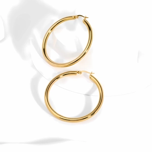 Detailed view of large 18K gold plated stainless steel hoop earrings on white surface