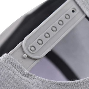 Detail of adjustable snapback closure on light gray baseball cap with twill texture