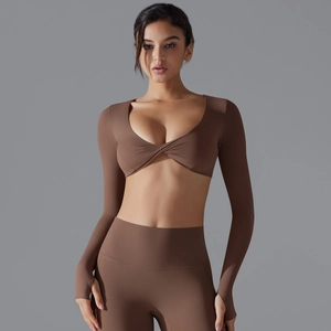 Dettaglio top crop marrone scuro a maniche lunghe con scollo a V e asole per i pollici