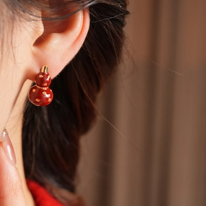 Detailed view of red and gold gourd earring worn by model for an elegant vintage look