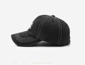 Detail of vintage washed black baseball cap with white contrast stitching and embroidery
