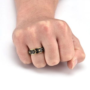 Close-up of rotatable gold celestial ring with sun, moon and star patterns