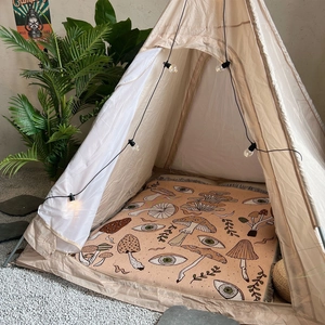 Bohemian camping blanket with mushroom patterns in a cozy indoor tent setup