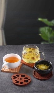 Creative lotus root shape wooden coasters for tea cups on dark stone surface