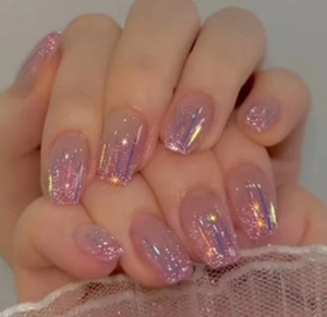 Detail of pink gradient press-on nails with glitter sequins and aurora starlight effects