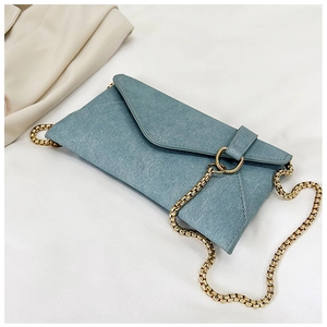 Top view of light blue denim envelope bag with gold ring buckle and chain strap detail