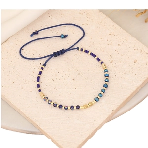 Handcrafted woven rope bracelet with blue faceted beads and gold accents on stone