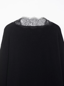 Detailed close-up of V-neck eyelash lace trim on black elegant knit sweater