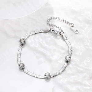 Detail of silver snake chain bracelet with five bezel-set zircon stones on white background