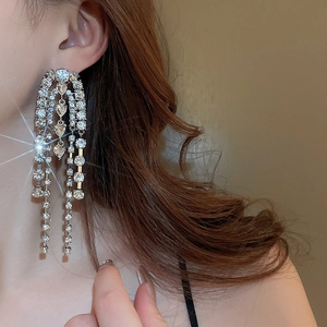Close-up of sparkling long tassel earrings with silver drop chain and rhinestones