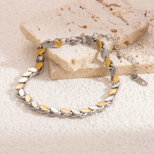 Detail of silver and gold leaf-shaped link bracelet with lobster clasp on stone
