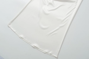 Détail en gros plan du tissu de satin blanc lisse avec drapé doux et fini brillant