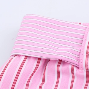 Macro shot of pink and white striped cotton fabric with precise stitching details