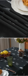 Close-up of reindeer and Christmas tree embroidery on black cotton linen tablecloth