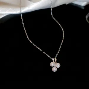 Minimalist stainless steel necklace with three-pearl zircon pendant on black silk background