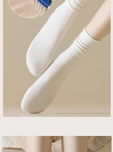 Close-up of white cotton crew socks showing soft knit texture and elastic fit on legs