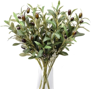 Close-up of realistic artificial olive branches with dark fruits in a clear glass vase