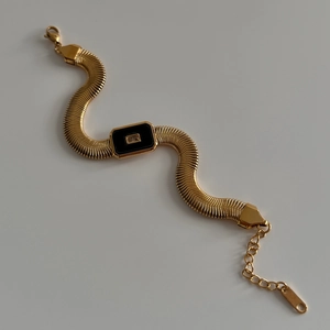 Detailed view of 18k gold plated snake chain bracelet with a black rectangular pendant