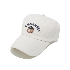 Dettaglio del cappellino di cotone bianco con ricamo a forma di orso e scritte blu