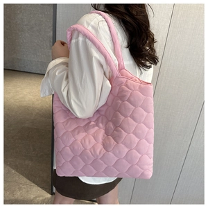 Close-up of pink quilted puffer tote bag with wave texture showing large capacity detail