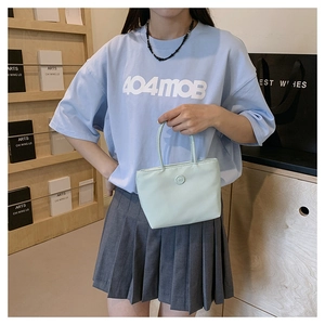 Détail du mini sac seau en nylon vert clair avec décoration circulaire lettre m