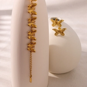 Golden stainless steel butterfly jewelry set featuring a bracelet and matching stud earrings