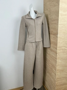 Detail of beige knit sweater jacket and wide-leg trousers set on a mannequin