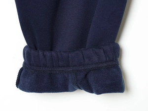 Close-up of dark blue ribbed knit fabric with warm fleece lining and neat stitching