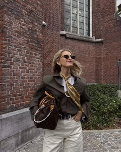 Outdoor street style view of a brown plaid shirt paired with beige casual trousers