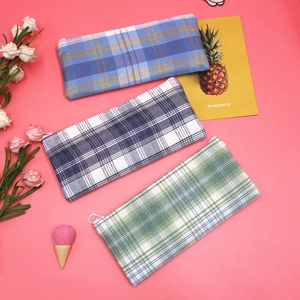 Detailed view of checkered canvas pencil cases with zipper closure in three colors