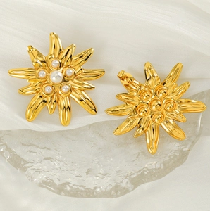Vue détaillée des boucles d'oreilles fleurs en acier titane plaqué or 18K et perle