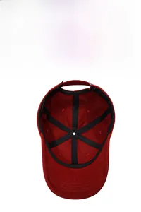 Inside view of dark red cotton baseball cap showing reinforced seams and adjustable strap