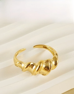 Detailed view of irregular 18K gold plated stainless steel ring with twisted wave texture