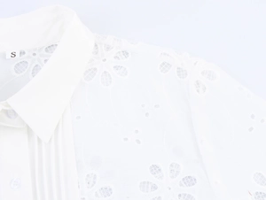 Detail of white French blouse showing delicate lace floral embroidery and size S label