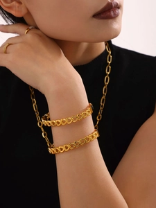 Detail of 18K gold-plated heart-shaped hollow chain bracelet on a model's wrist