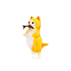 Cute enamel orange and white cat brooch with fish charm on white reflective surface