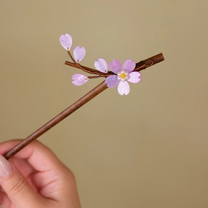 Close-up of bamboo hair stick featuring delicate pink cherry blossoms and glass beads