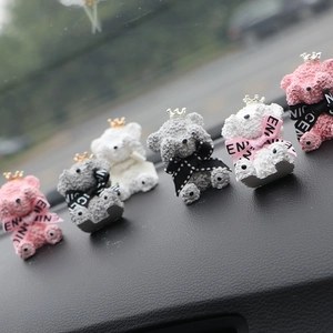 Group of colorful crown teddy bear car air vent clips on a dashboard interior display