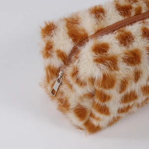 Macro shot of plush giraffe print makeup bag showing soft texture and metal zipper