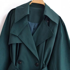 Classic dark green trench coat featuring double-breasted buttons and refined twill texture
