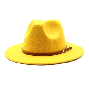 Detail of yellow wool fedora hat featuring a brown faux leather band and metal rivet