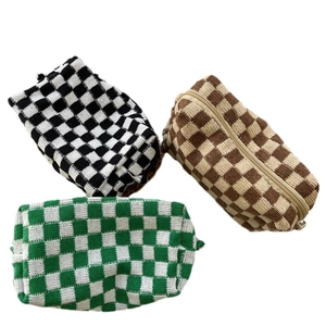 Three-color checkerboard knit makeup bags with zipper closures in a high-quality flat lay view