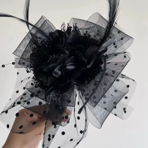 Detail of black polka dot mesh flower headband with feathers and beaded accents