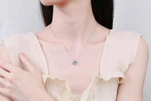 Close-up of model wearing S925 sterling silver necklace with 4-prong moissanite pendant