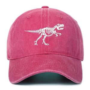 Detailed view of white dinosaur skeleton embroidery on washed pink cotton baseball cap