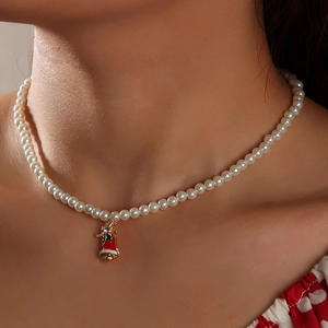 Detailed close-up of a pearl necklace with a festive red Christmas bell pendant for women
