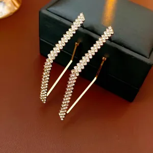 Luxury geometric diamond earrings with zigzag shape and gold finish on jewelry box